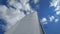 The snow-white sails of the yacht against the background of bright blue sky and white clouds