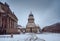Snow and winter panoramic view of famous Gendarmenmarkt square with Berlin Concert Hall and German Cathedral. Early