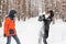 Snowball fight. Winter couple having fun playing in snow outdoors.