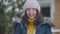 Snowball hitting face of beautiful young Caucasian woman in slow motion. Portrait of laughing joyful charming lady