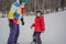 Snowboard instructor teaches a boy to snowboarding. Activities for children in winter. Children`s winter sport