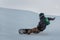 Snowboarder in a black helmet riding on a snowy track.