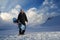 Snowboarder in black suit standing on trackand looks side