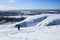 Snowboarder climbing the snow mountain and arctic landscape behind him