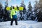 Snowboarder climbing to mountain top carrying his snowboard through forest for backcountry freeride and wearing