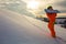 Snowboarder climbing on the top of ski slope