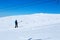 Snowboarder climbs a lift on a mountain against a blue sky