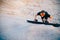 Snowboarder climbs to top of sand dune for snowboarding