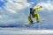 Snowboarder does the jumping trick. snow scatters pieces