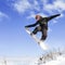 Snowboarder doing high jump above the mountain