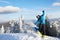 Snowboarder doing tricks at ski resort. Rider performing jump with his snowboard near forest on backcountry freeride or