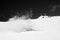 Snowboarder fall down with snow splashes on snowy ski slope. High contrast. Black and white