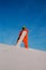 Snowboarder freerider with white snowboard standing on the top of the ski slope