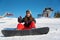 Snowboarder girl sitting in snow showing thumbs up gestures class