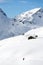 Snowboarder goes downhill over a snowy mountain landscape.