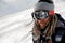 Snowboarder guy with dreadlocks standing on the slope in the protective glasses