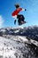 Snowboarder jumping against blue sky