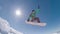 Snowboarder jumping against blue sky