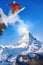 Snowboarder jumping against Matterhorn peak in Switzerland