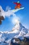 Snowboarder jumping against Matterhorn peak in Switzerland