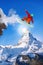 Snowboarder jumping against Matterhorn peak in Switzerland