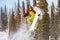 Snowboarder jumps at offpiste slope