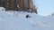 A snowboarder jumps small distance with grab on a natural springboard in powder.