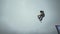 Snowboarder make extreme jump from trampoline in snowy mountain. grey cloud sky. Ski resort