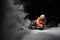 Snowboarder in orange jacket riding on a snowy hill at night