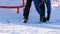 Snowboarder puts on or removes a snowboard on a winter day, speaking downhill