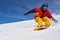 Snowboarder riding fast on dry snow freeride slope.