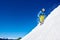 Snowboarder riding snowboard down snowy mountain slope on sunny winter day. Extreme sport concept.