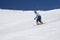 Snowboarder riding on snowy ski slope at high winter mountains in sunny day