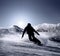 Snowboarder silhouette goes down by the high mountain ski slope