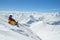 Snowboarder sits high in mountains on the edge of slope