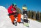 Snowboarder sitting in the snow at ski resort,using his smart phone while resting in the mountains