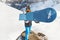 Snowboarder in ski mask and funny hat holds blue snowboard in front of the camera