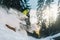 Snowboarder with special equipment is riding and jumping very fast in the mountain forest