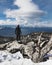 Snowboarder standing alone at summit gazing down upon Lake Tahoe and Snow Capped Mountains