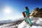 Snowboarder stands on valley and mountains backdrop