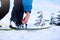 Snowboarder straps in his legs in snowboard boots in modern fast flow bindings with straps. Rider at ski resort prepares