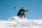 Snowboarder in stylish sportswear riding down the powder snow hill