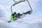 Snowboarder using ski lift at mountain resort