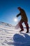 Snowboarder walking against blue sky