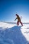 Snowboarder walking against blue sky