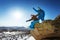 Snowboarders stand on blue sky backdrop in mountains