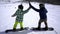 Snowboarding in the ski resort. two friends greet each other and start riding on a snowy slope