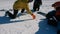 Snowboarding teacher explains to the students the technique of snowboarding, drawing diagrams on the snow.