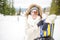 Snowboarding.Young beautiful woman with ski mask holding her snowboard at ski slope Young woman in ski resort