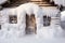 snowdrift covering entire front door of a cozy cabin